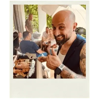 Polaroid-Foto eines lachenden SOL TRAIN Mitarbeiters beim Team-Grillen